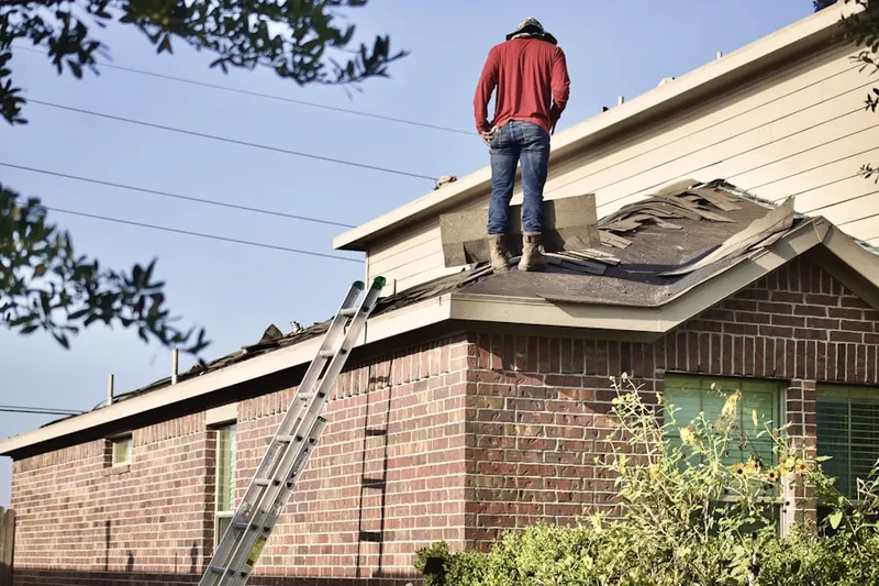 Professional roofer working on a residential roof in Winona